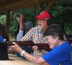 Photo of Bruce Mikesell, certified instructor watching as first time shooter Katheleen Nealeigh of Greenville, OH, as she aims.